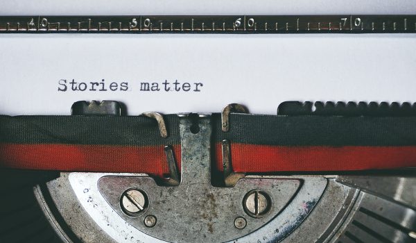 Close up photo of a typewriter with the words 'stories matter' printed on a page